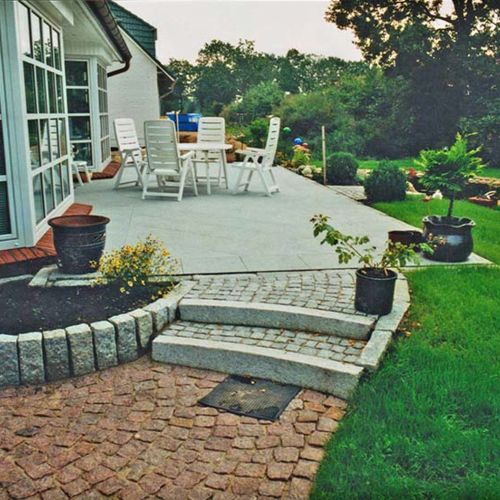 Terrasse mit Granitplatten, Kleinpflaster und Stufenanlage aus Granitstelen